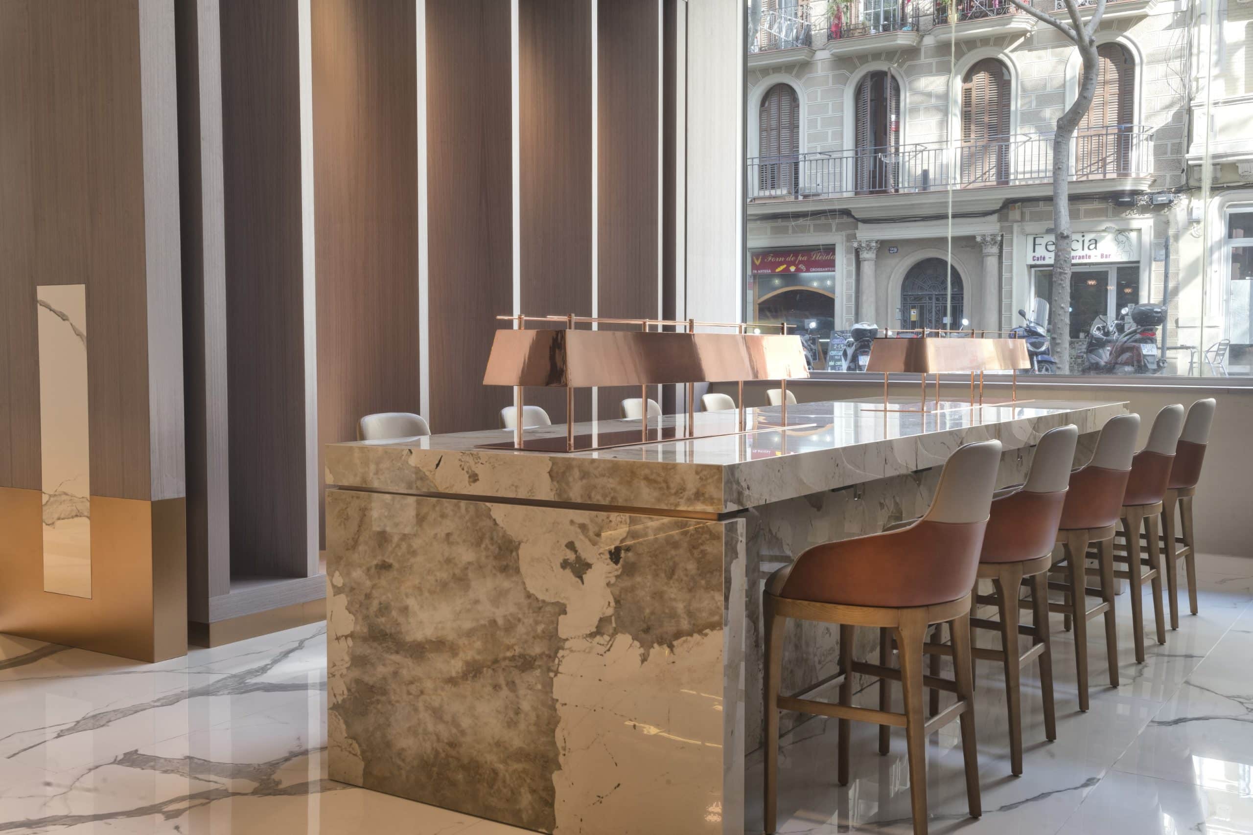 Table en granit dekton khalo entouré de chaises hautes dans un restaurant