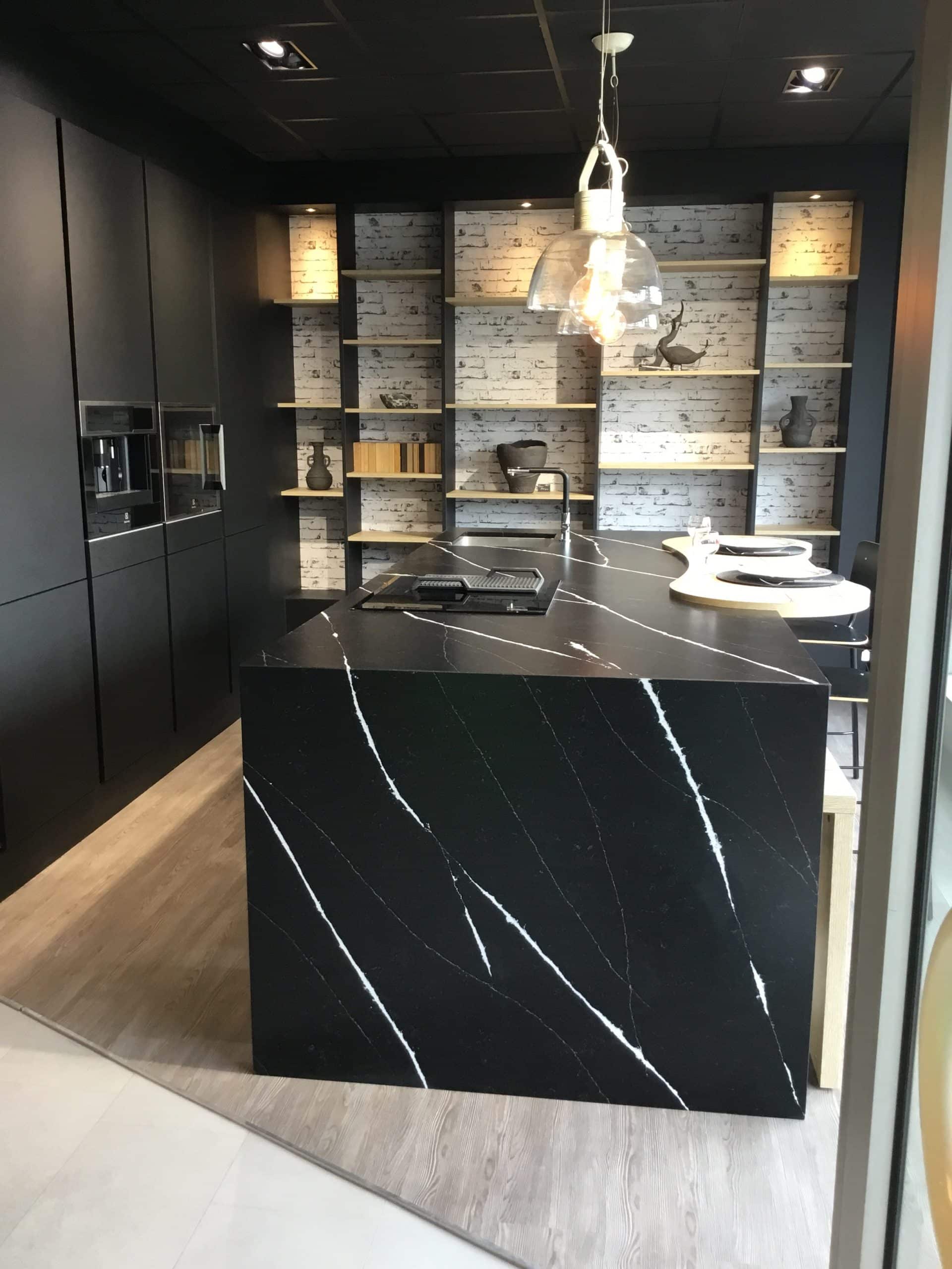 Plan de travail en marbre noir silestone et marquina avec une plaque de cuisson et un évier