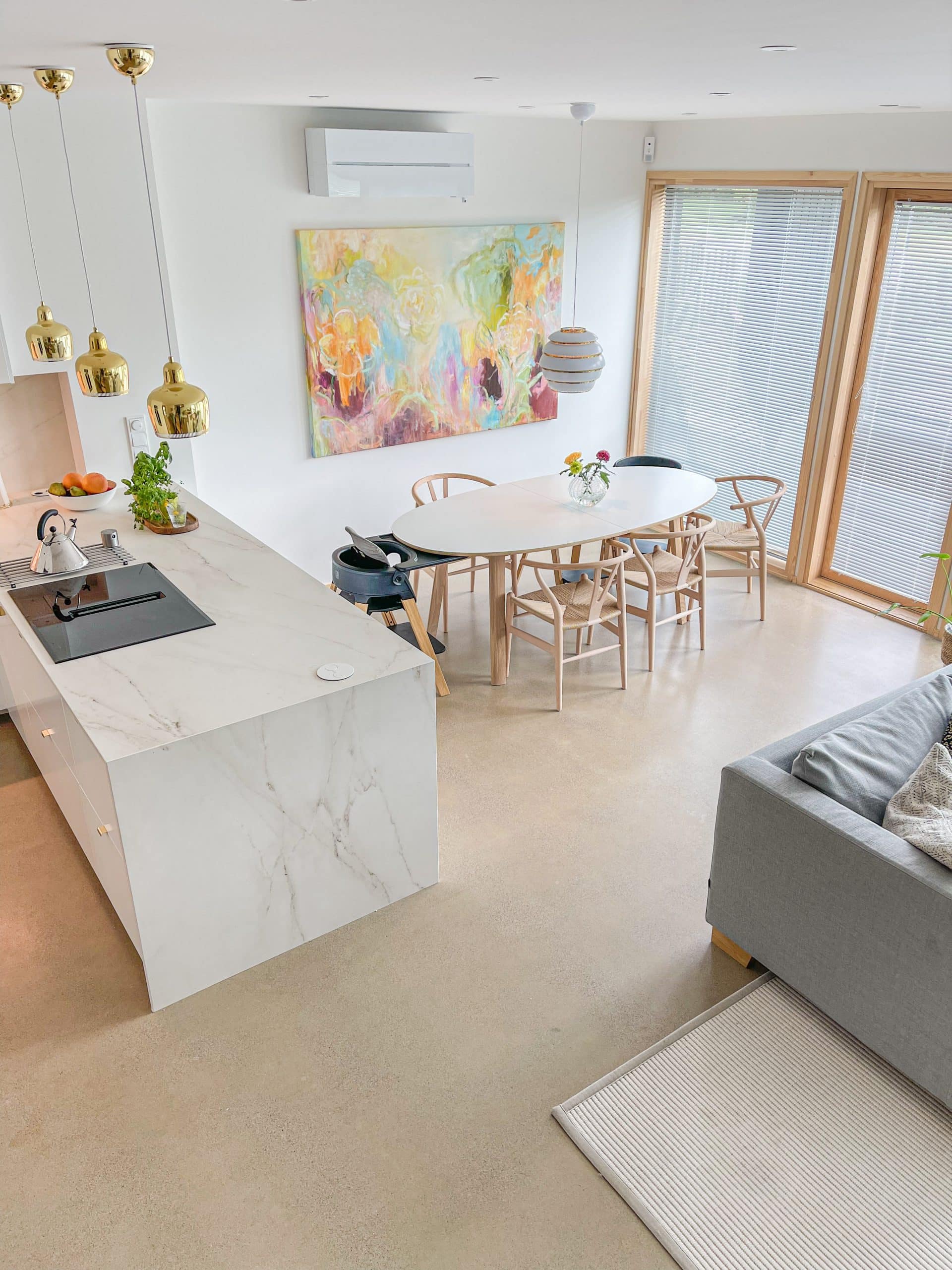 Plan de travail en marbre Dekton Rem avec une plaque vitrocéramique dans une cuisine moderne, colorée et boisée