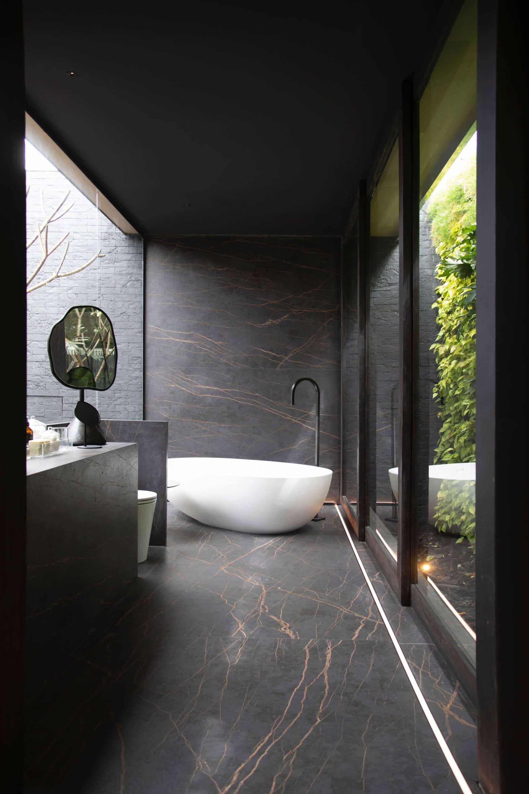 Salle de bain avec un sol, un mur et un meuble en Dekton Laurent avec une baignoire en arrière plan