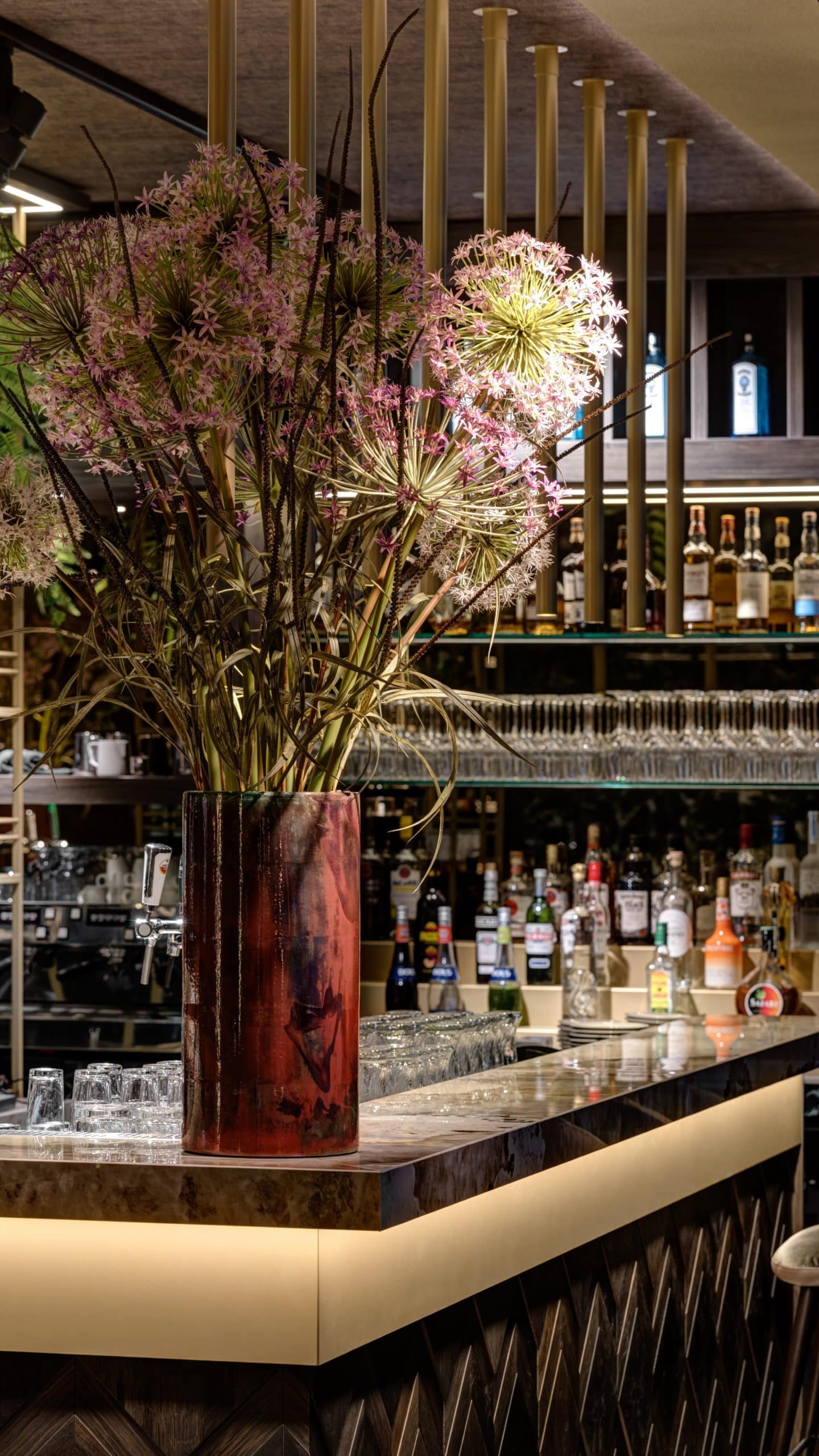 Pot de fleur design sur un bar en granit Dekton Khalo dans un restaurant