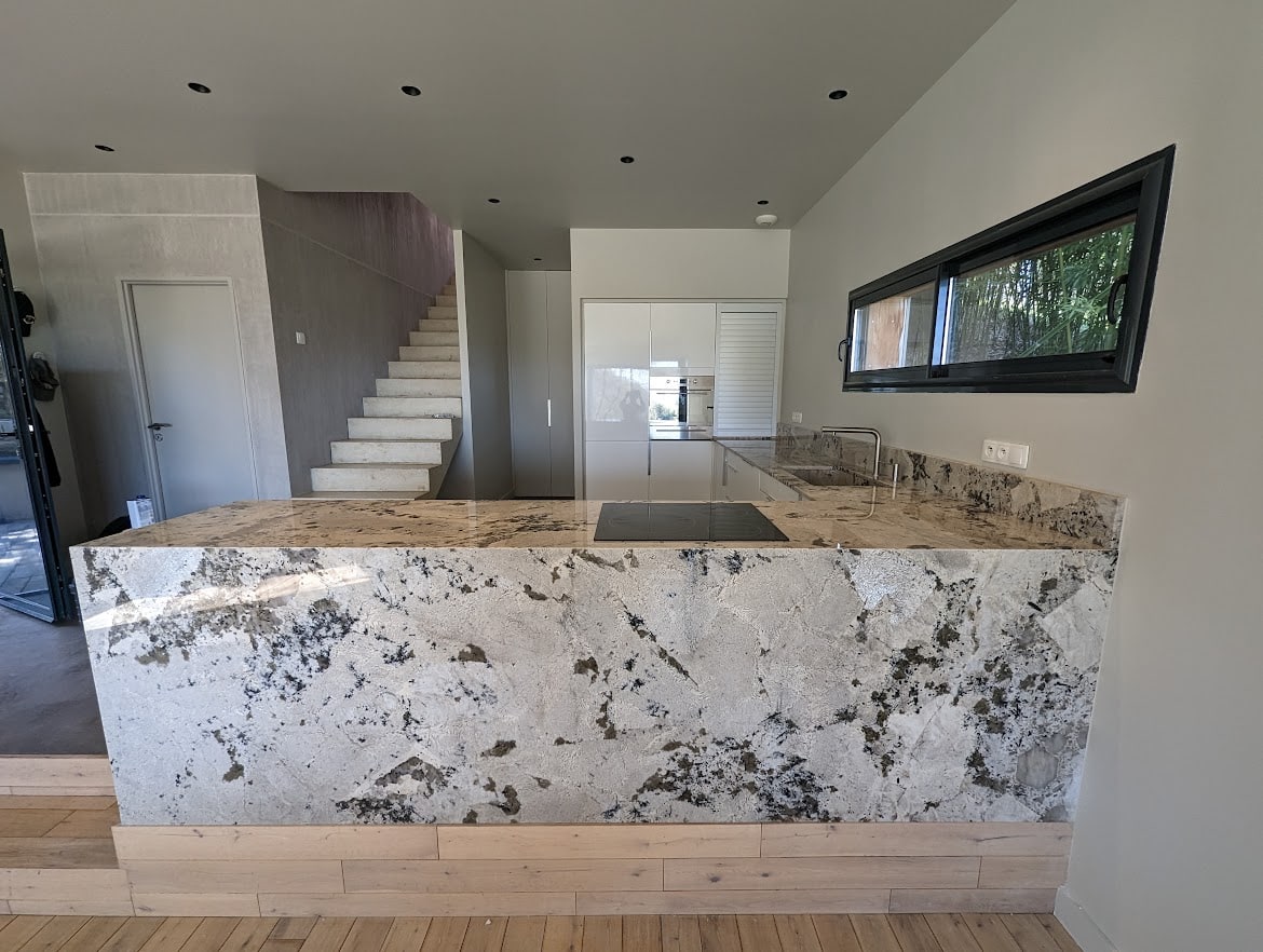 plan de travail en forme de L en quartzite white babylon dans une cuisine claire et moderne