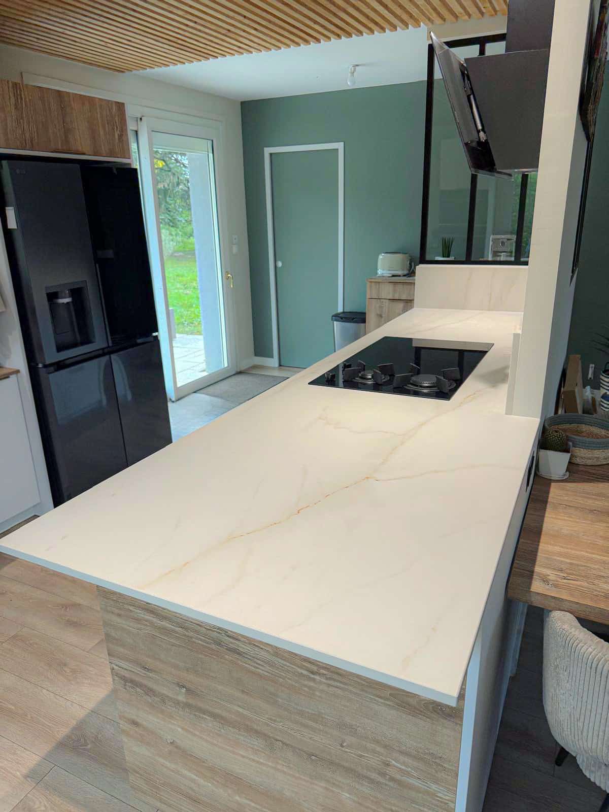 Plan de travail en céramique Laminam marble gold au milieu d'une cuisine claire et moderne vu de derrière