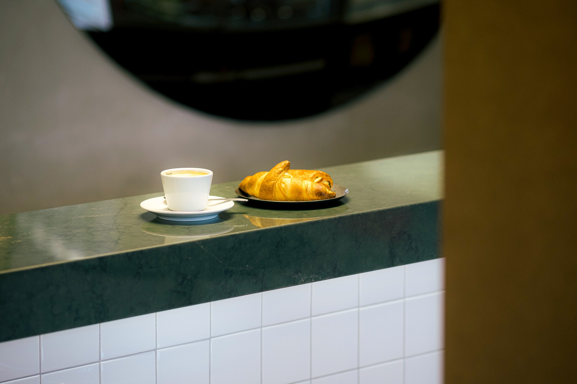 Café et croissant sur un bar sur mesure vert