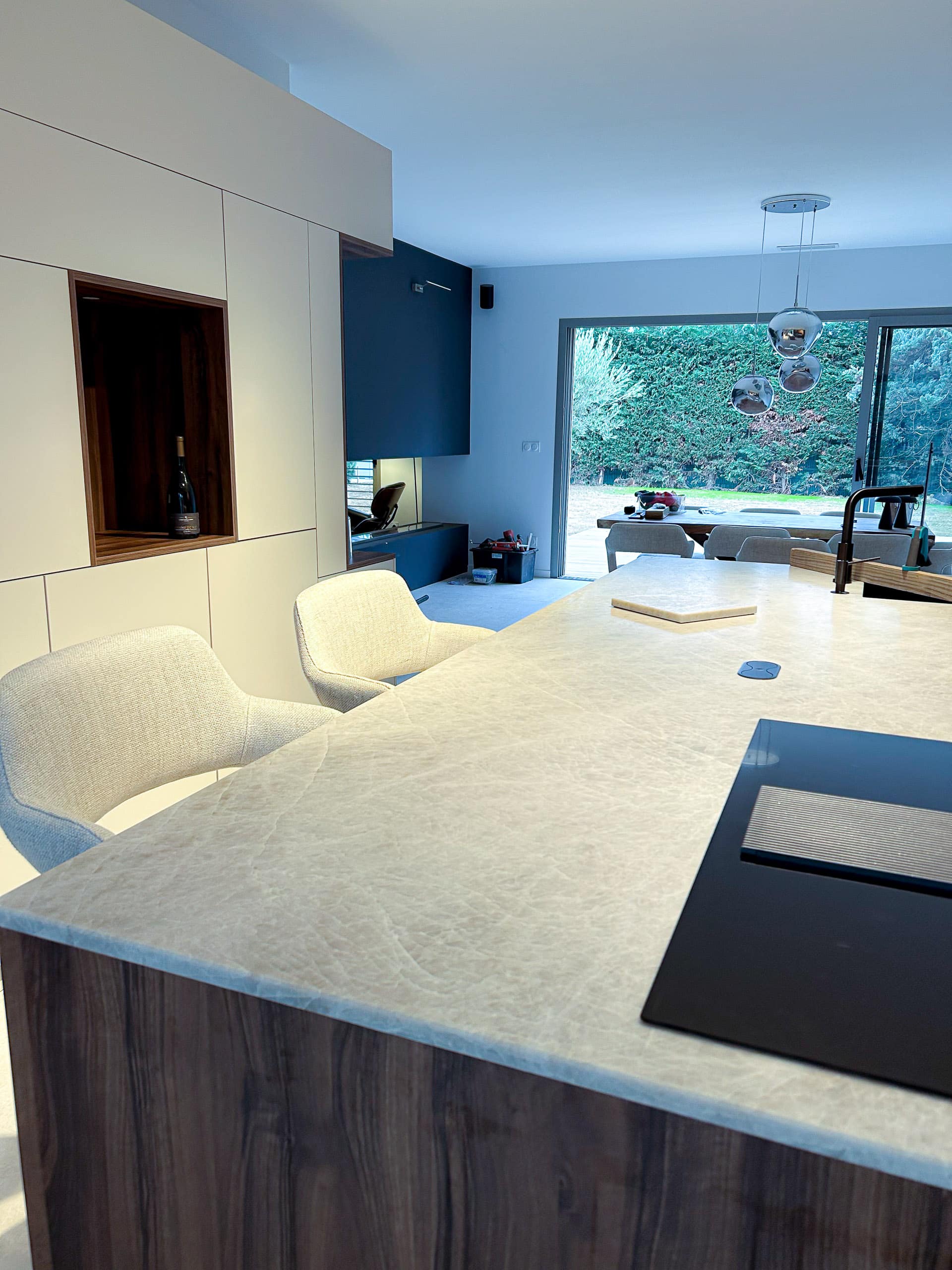 îlot central en pierre naturelle Taj mahal avec deux chaises hautes blanches modernes