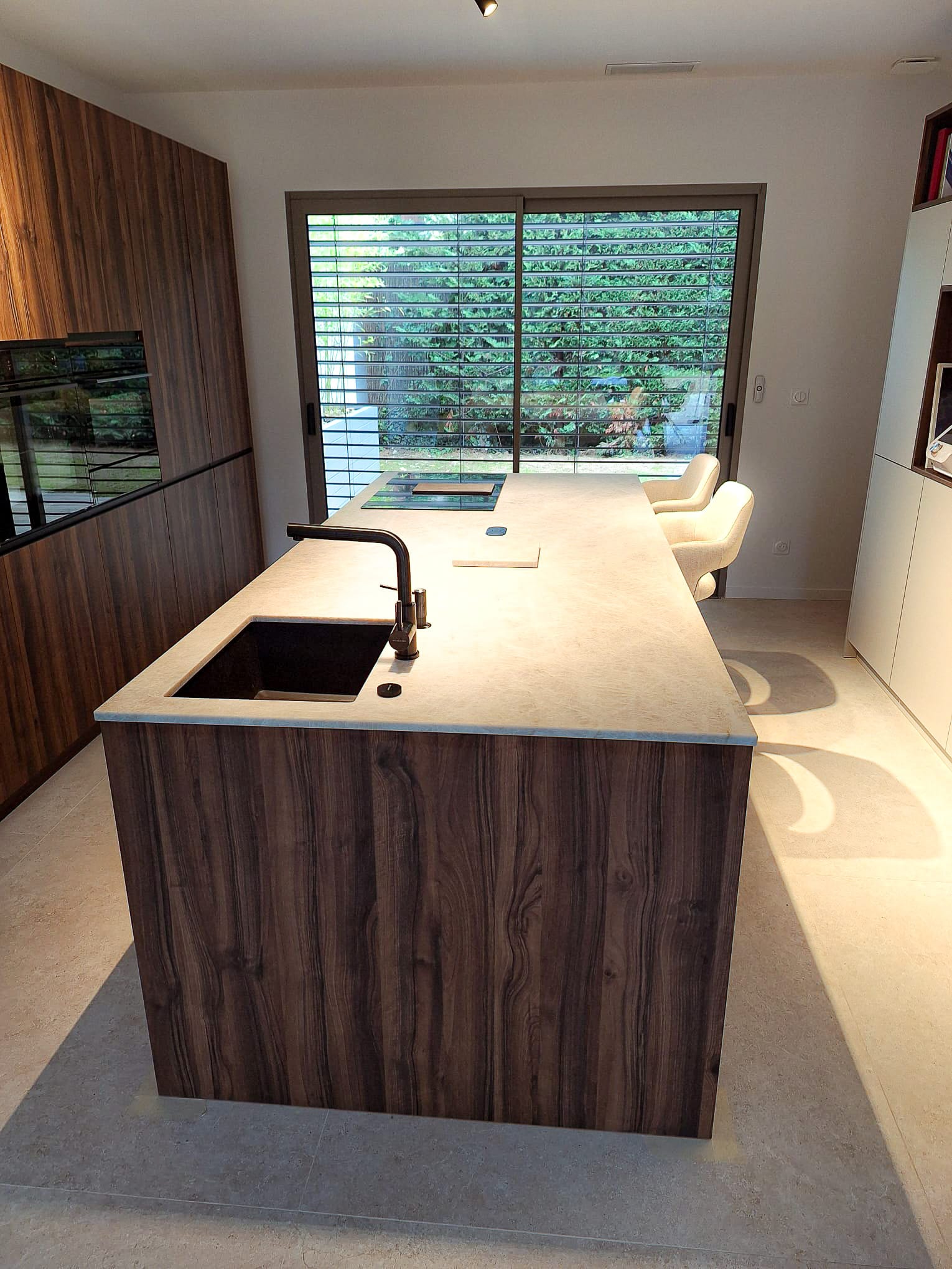 Plan de travail en Quartzite Taj Mahal sur un meuble en bois dans une cuisine claire naturelle et moderne